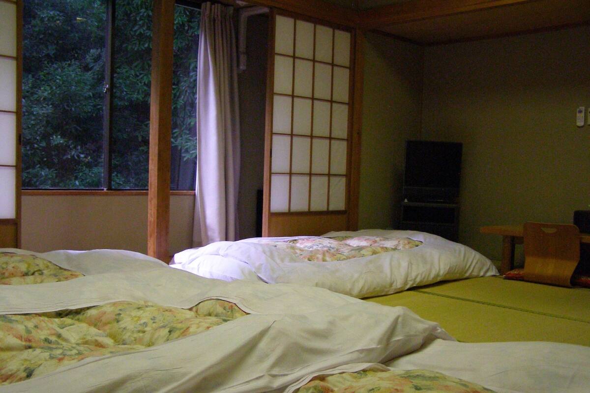 Habitació tradicional japonesa amb tatami, una taula baixa i una porta corredissa.