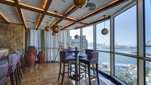 Un restaurante en un edificio alto con vistas panorámicas de la ciudad y del agua.