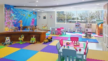 Children can play and explore in this vibrant playroom with a large underwater mural and colorful play equipment.