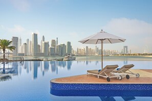 Piscine couverte, piscine extérieure, parasols de plage, chaises longues