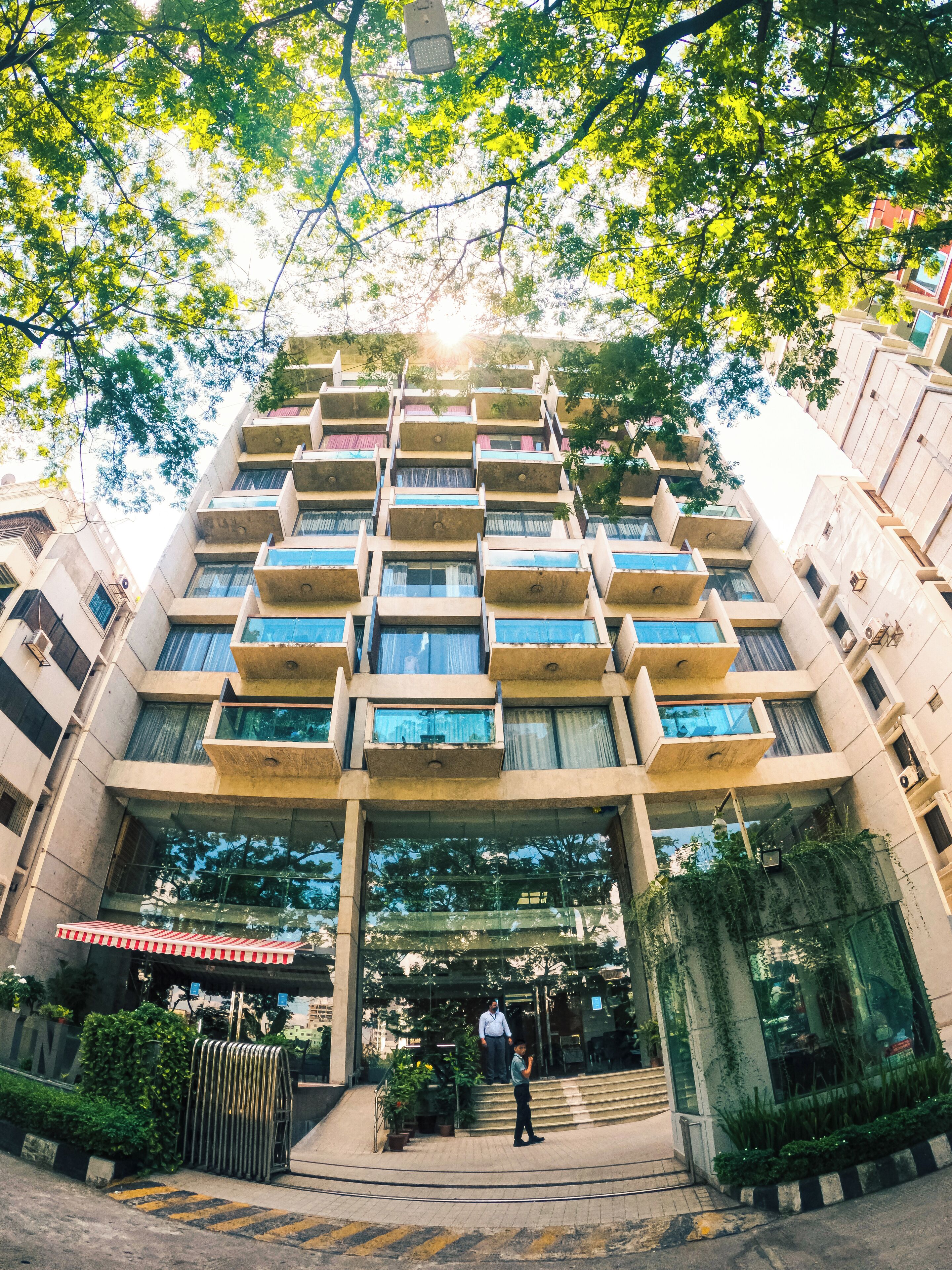 A multi-story building with a central entrance, balconies, and a staircase leading to the entrance.