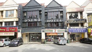Een hotel met een opvallend bord, een 7-Eleven winkel en een kliniek aan de overkant van de straat.