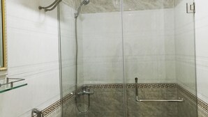 Un baño con ducha de vidrio, inodoro y lavabo.