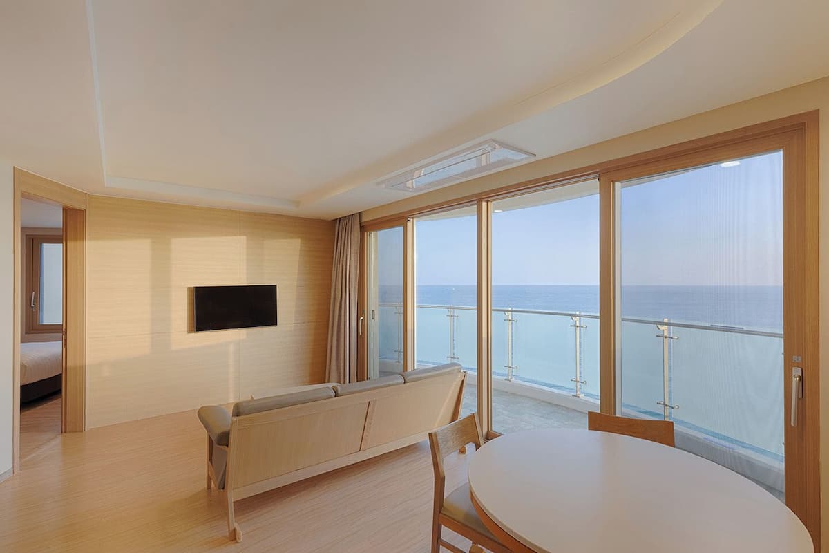 A modern room with a balcony, a sofa, a table, and a TV.