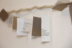 Una pared con varias etiquetas colgantes, cada una con texto y una pequeña etiqueta marrón.
