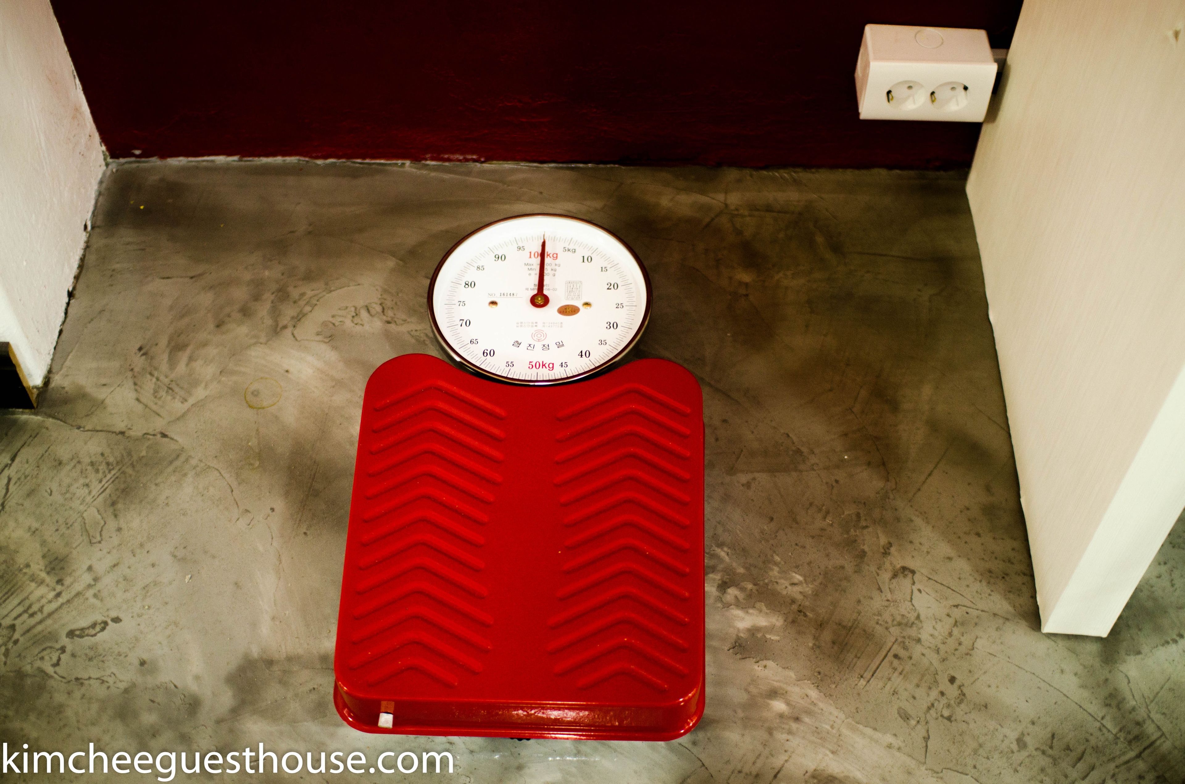A red step platform with a built-in weighing scale.