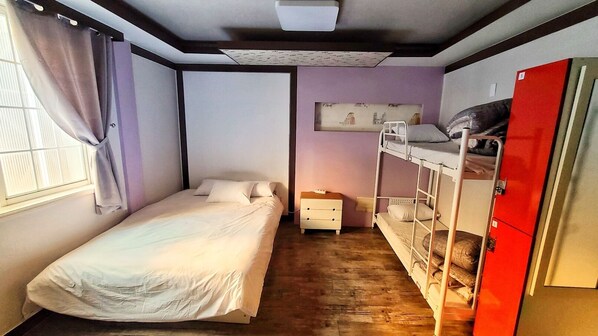 A compact room with a bunk bed, a single bed, a small dresser, and a window with curtains. - Kimchee Busan Downtown Guesthouse - Hostel (Busan)