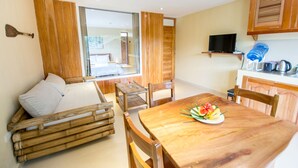 Une pièce chaleureuse avec une table à manger en bois, un canapé et une grande fenêtre.