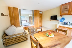 Una habitación acogedora con una mesa de madera, un sofá y un ventanal grande.