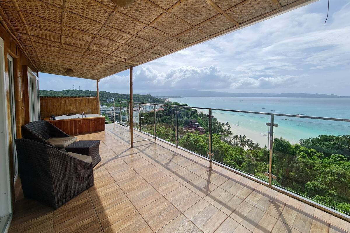 Un balcon avec vue sur la mer et un plafond en bois.