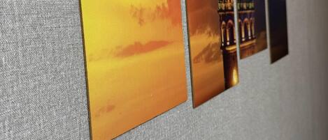 A wall with four framed photographs of a building with a tower, possibly a historical landmark, displayed in a row.