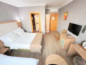 A hotel room with a large bed, a desk with a TV, a small table, and a chair. There is a bathroom visible through an open door. - Lounge Boutique Hotel (Istanbul)