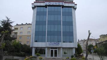 Un edificio moderno con un cartel que dice "LOUNGE BOUTIQUE HOTEL" en la entrada.