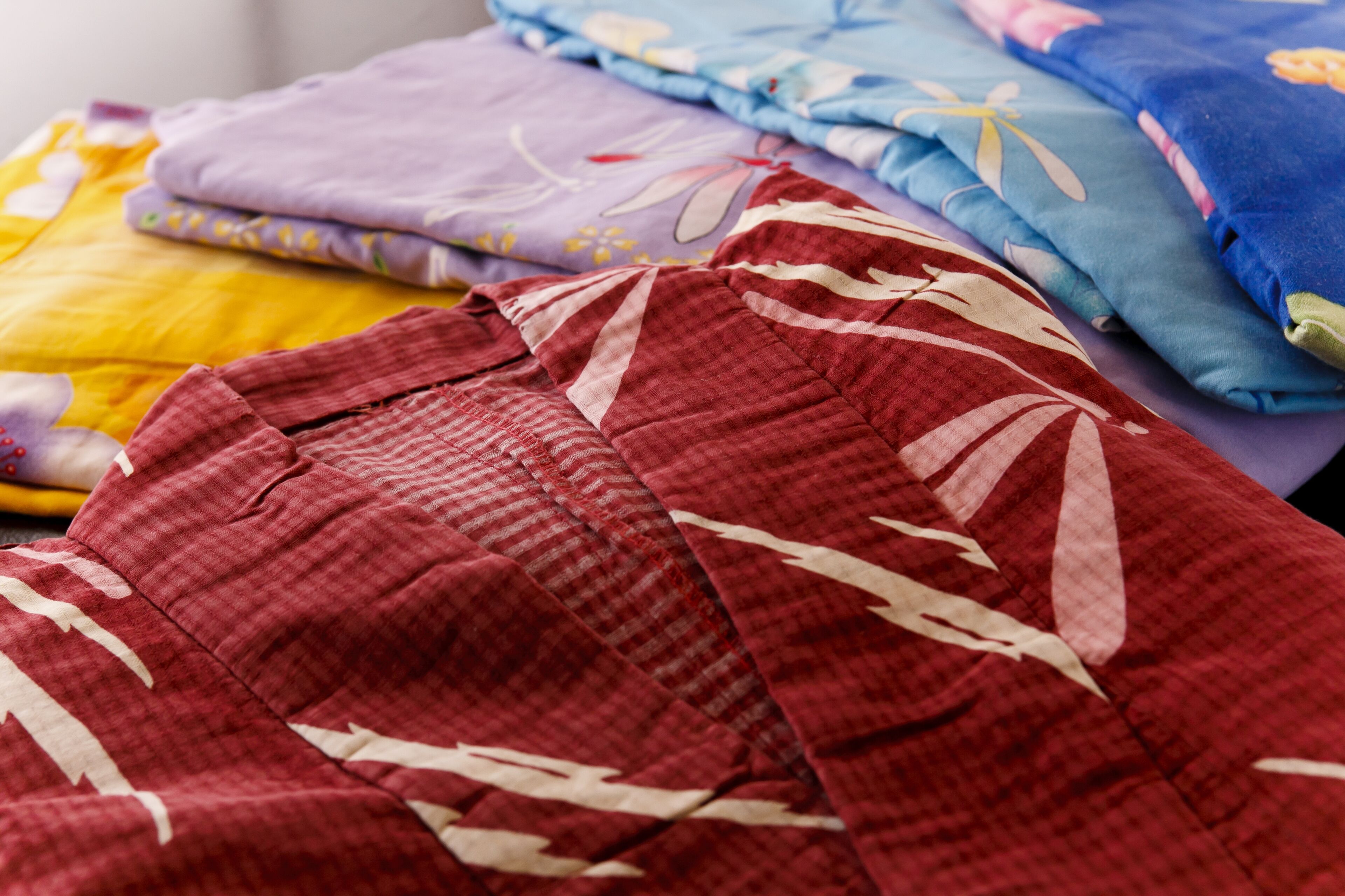 A stack of folded blankets in various colors and patterns.