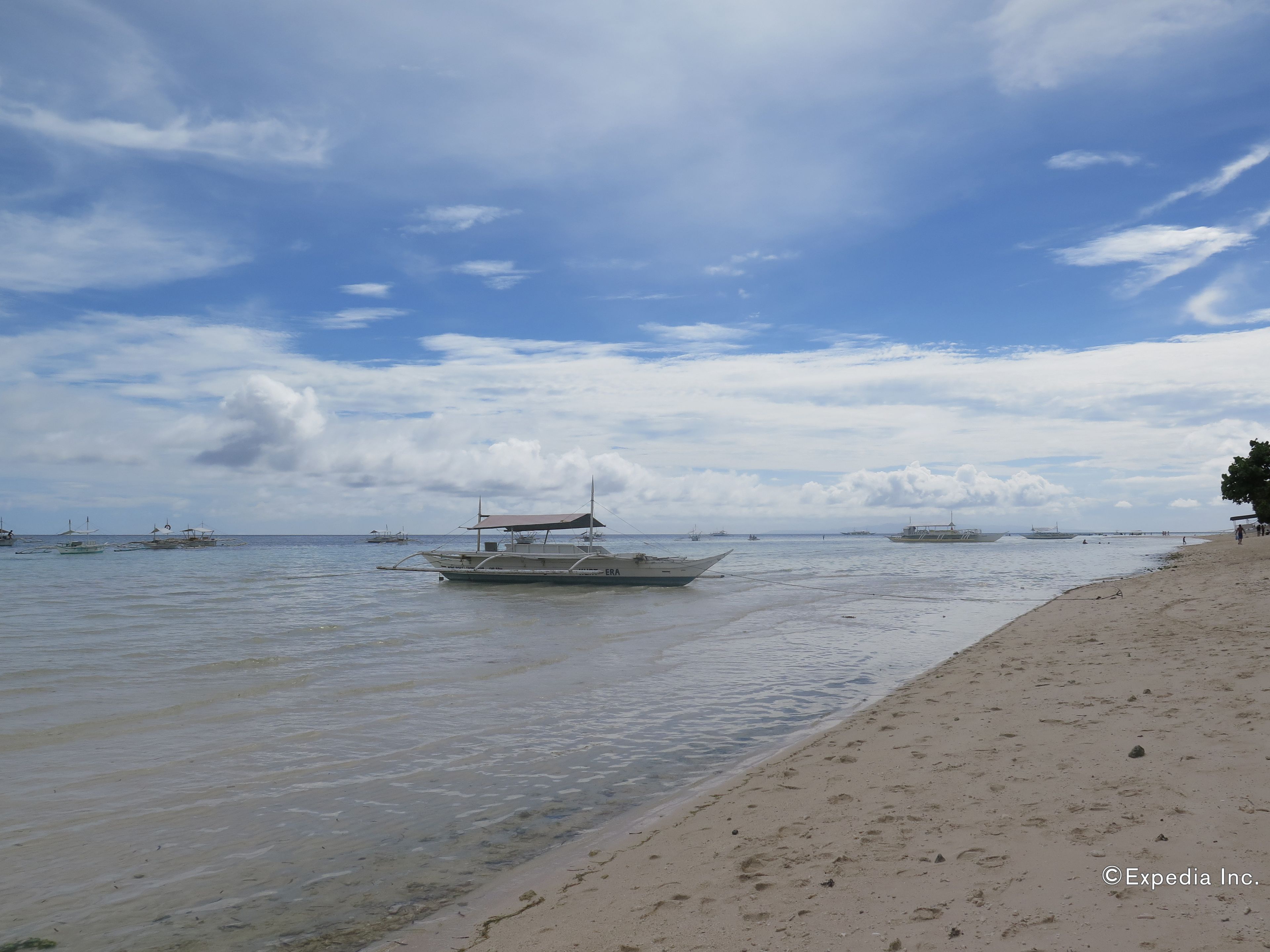 A beach with boats and a clear sky.