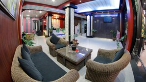 A lobby with wicker furniture, a coffee table, and potted plants. - Shunda Hotel Bali (Denpasar)