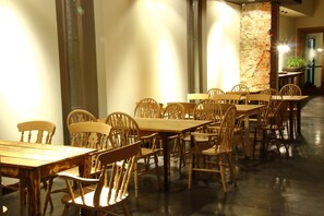 Enjoy meals in a warm and inviting dining area with wooden tables and classic chairs.