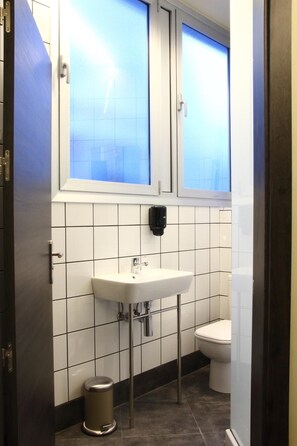 Bathroom features a sink, toilet, and window.