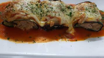 Un plato de calabacín relleno con queso y salsa de tomate.