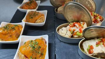 A table with various dishes, including a chicken dish with sauce and a side of diced vegetables.