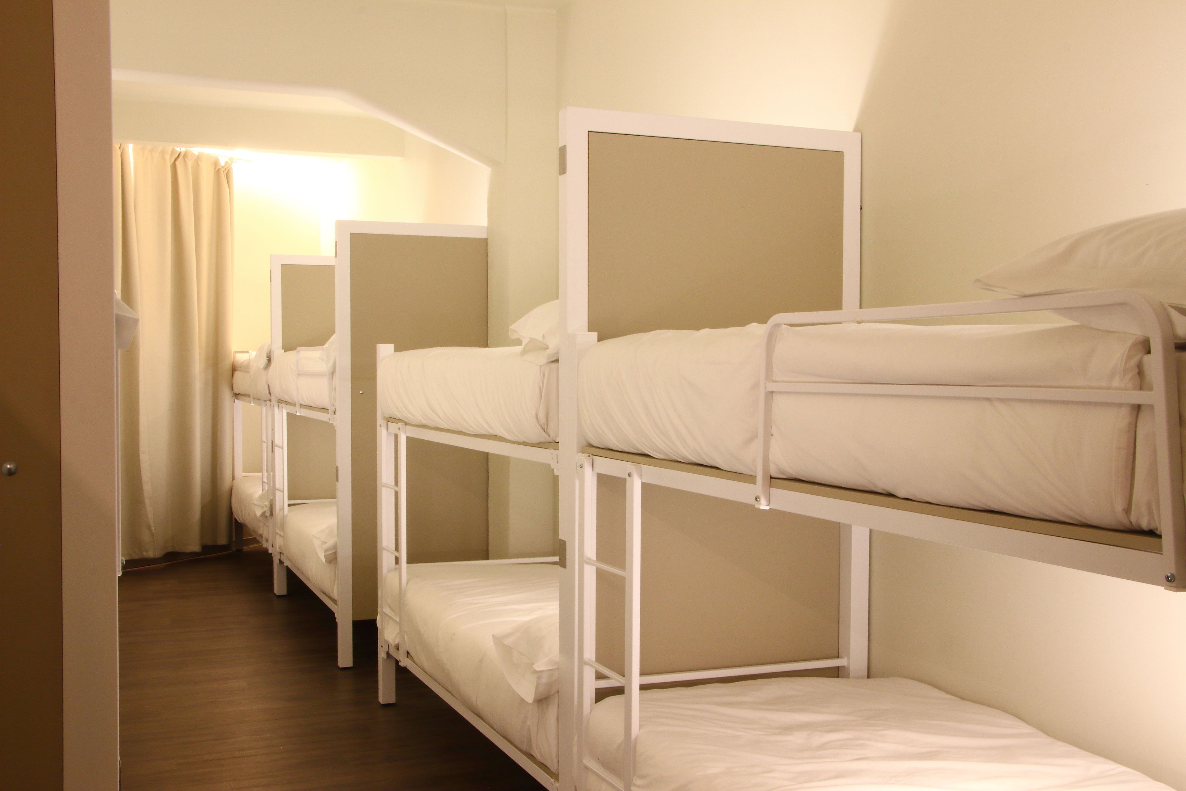 Una habitación con literas, suelo de madera y una puerta.