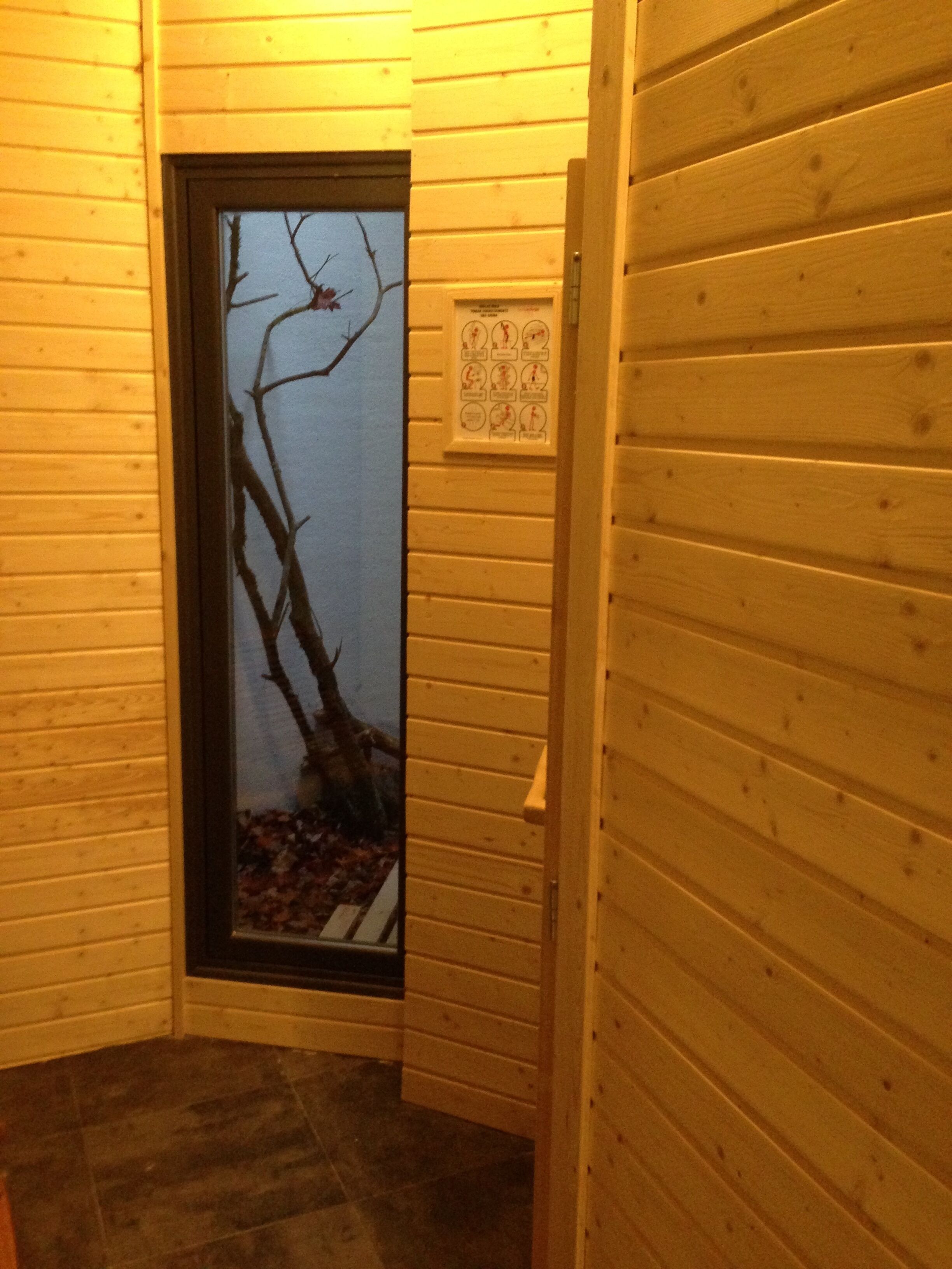 A wooden interior with a door leading to a dark room.