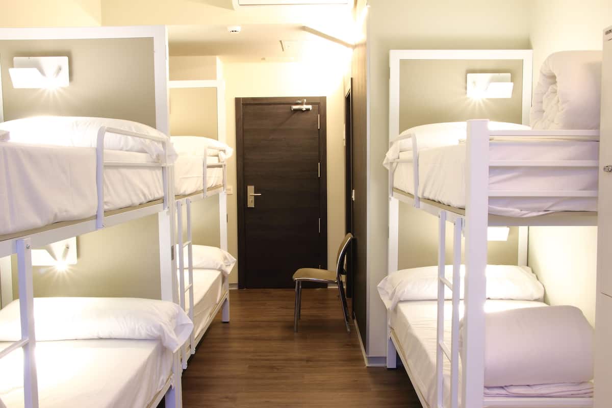 Une pièce avec des lits superposés, une porte et une chaise.