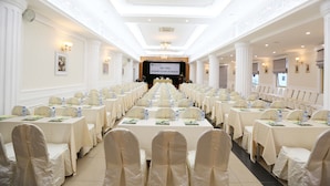 A banquet hall with rows of tables and chairs, a stage at the front, and decorative lighting. - Vietnam Trade Union in Hanoi (Hanoi)