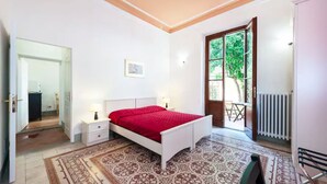 A bedroom with a bed, bedside tables, a radiator, and a view of the outdoors. - L'ARANCETO&STILNOVO GUEST HOUSE DI TOKA ALFONS (Florence)