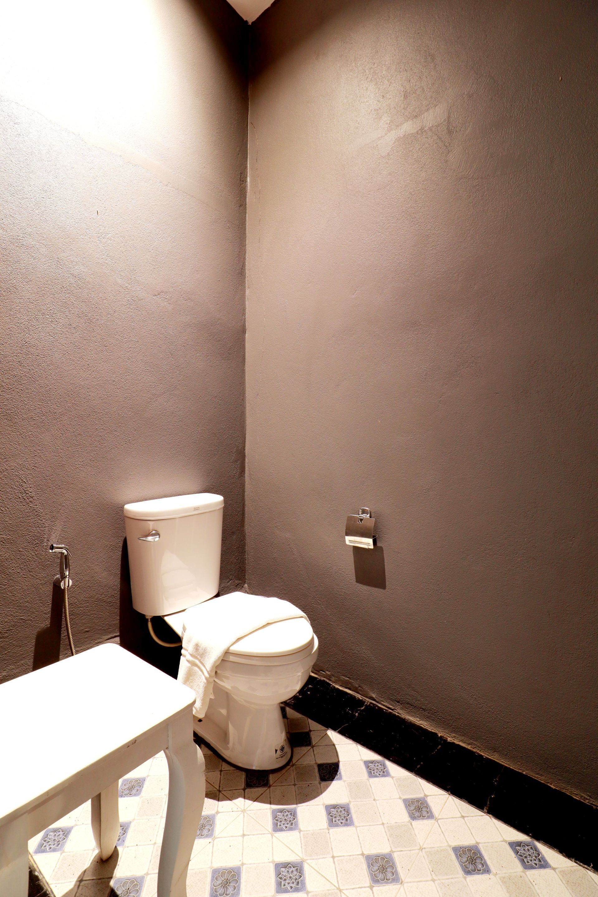 Une petite salle de bain comprenant des toilettes, un lavabo et un porte-serviettes.