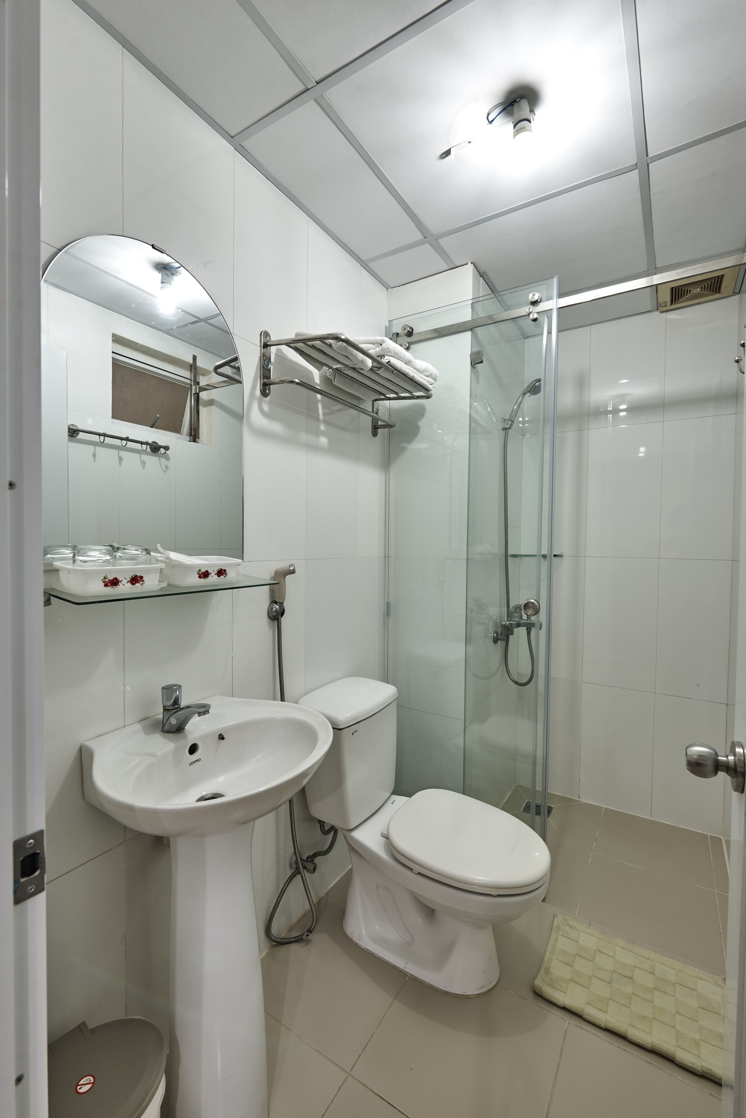 Une salle de bain moderne avec une douche à parois de verre, un lavabo sur colonne et des toilettes.