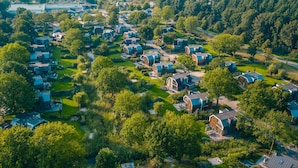 Vista aérea de una zona residencial con casas modernas, céspedes verdes y árboles.