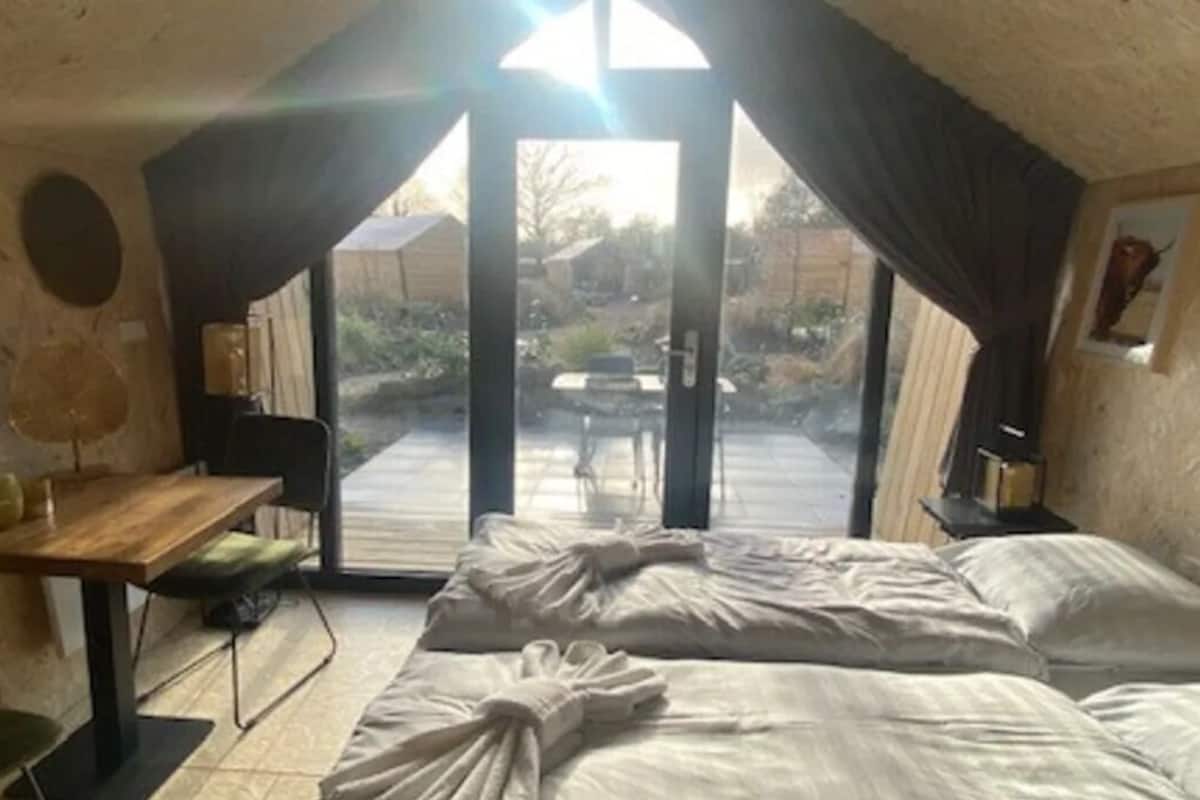 A room with a bed, a desk, a chair, and a TV.