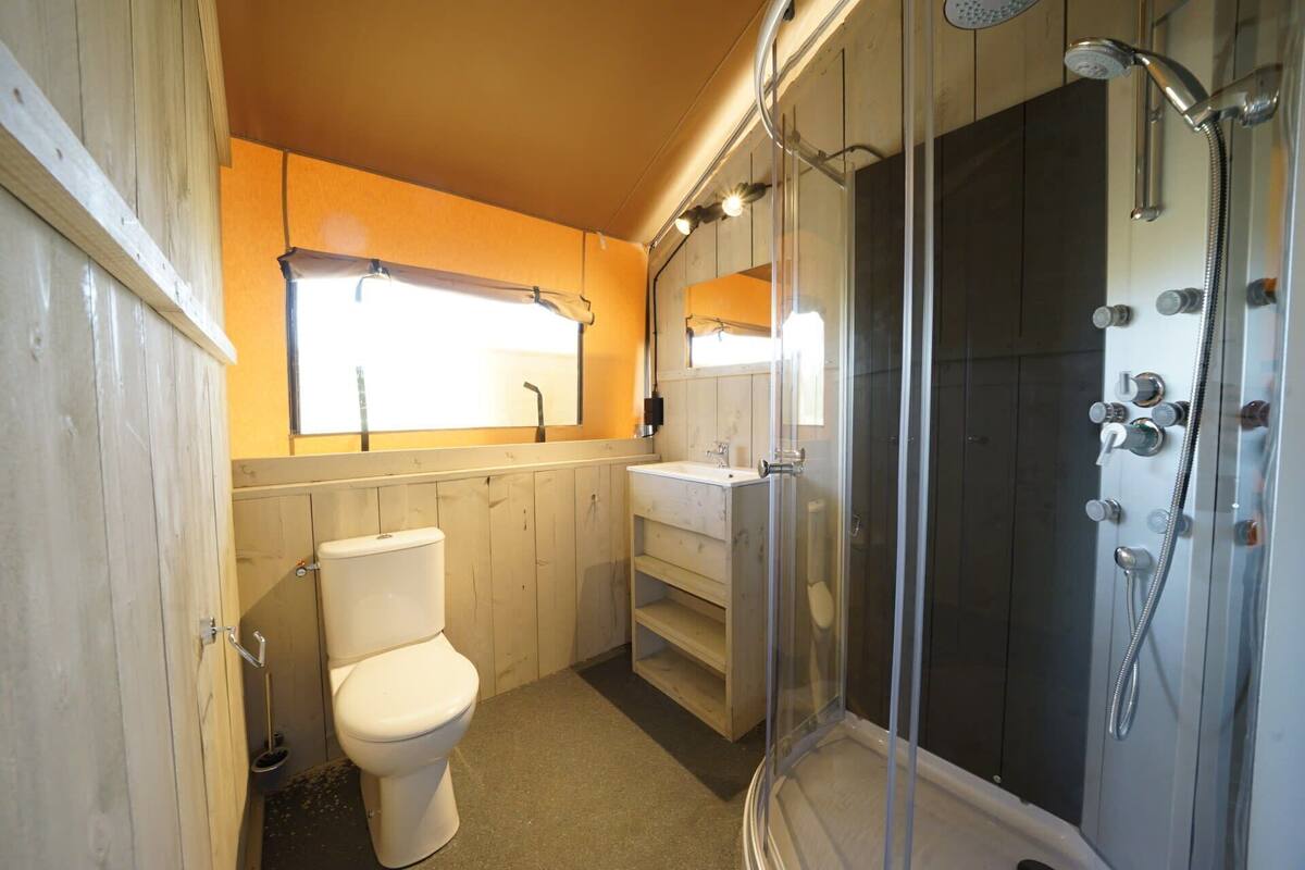 A bathroom with a toilet, sink, and shower.