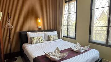 Una habitación de hotel con una cama, una lámpara de pared y una ventana con vistas.