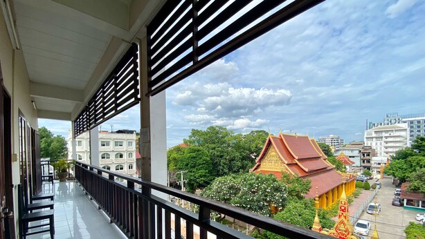 A balcony with a view of traditional architecture and a street below. - Mixay Paradise Hotel (Vientiane)