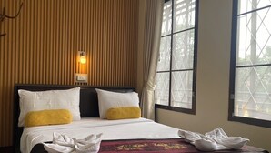 A hotel room with a bed, a wall-mounted light, and a window with a view of trees. - Mixay Paradise Hotel (Vientiane)