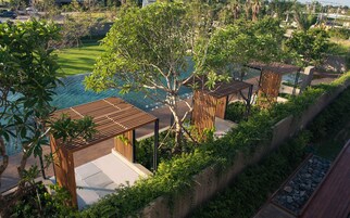 Una piscina al aire libre, sombrillas, sillones reclinables de piscina