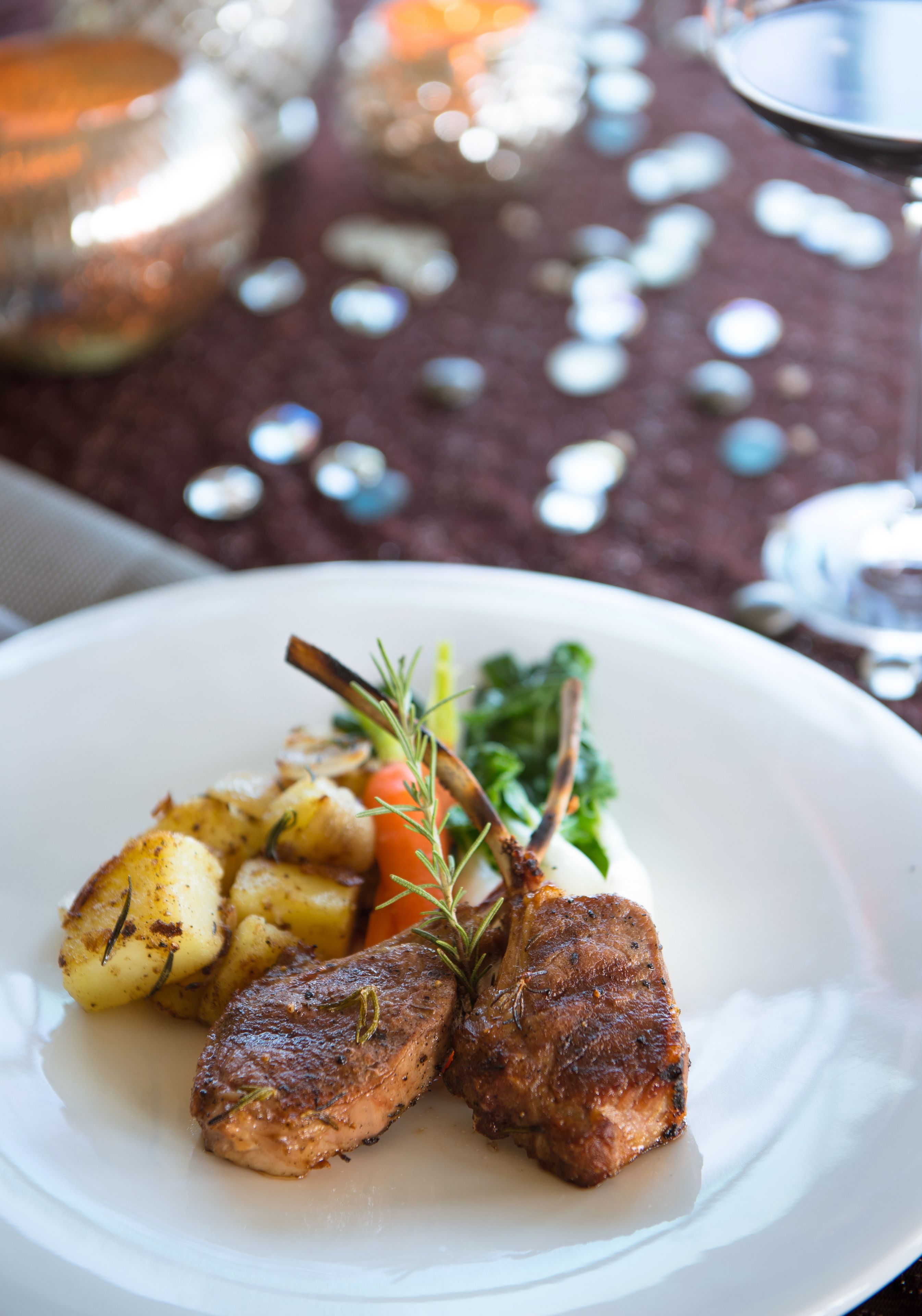 Une assiette de nourriture comprenant de la viande rôtie, des pommes de terre et des légumes.
