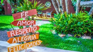 A wooden sign with multiple arrows pointing in different directions, each with a word written on it. - Manhã Dourada Pousada (Porto Seguro)
