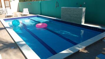 Piscina externa, piscina com cascata, guarda-sóis, espreguiçadeiras