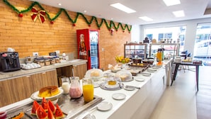 Un bufé de desayuno con diversas opciones de comida y un refrigerador de Coca-Cola.