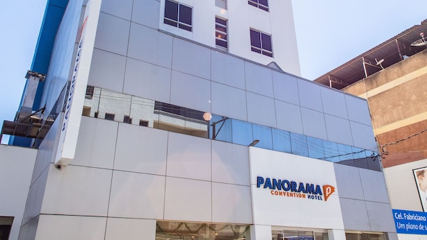 Un moderno edificio de hotel con un llamativo letrero que dice "PANORAMA CONVENTION HOTEL".