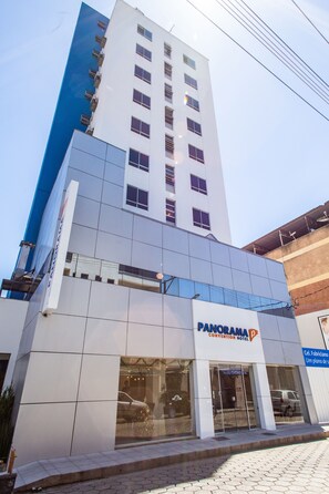 Un moderno edificio de hotel con un llamativo letrero que dice "PANORAMA CONVENTION HOTEL".