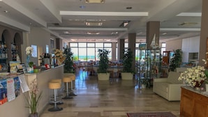 A spacious lobby with a bar area, seating, and a view of the ocean. - Hotel Excelsior (Cattolica)
