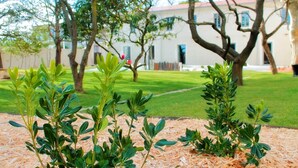 A landscaped area with young trees and a building in the background. - Hotel Mas de Boudan (Nîmes)