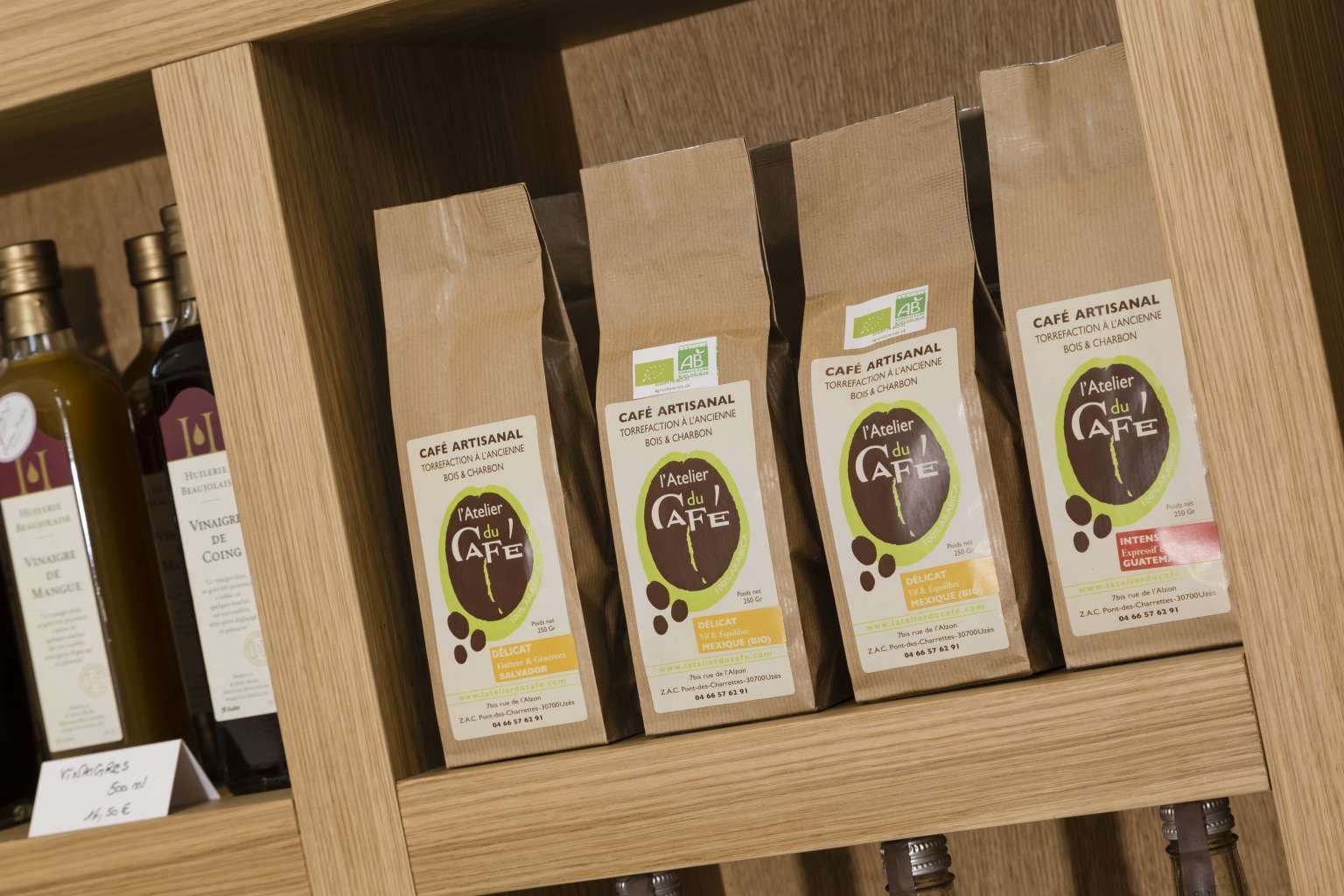 Estant amb diversos productes envaselats etiquetats com 'Café Artisanal'.