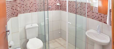 A bathroom with a glass shower enclosure, a toilet, and a sink.