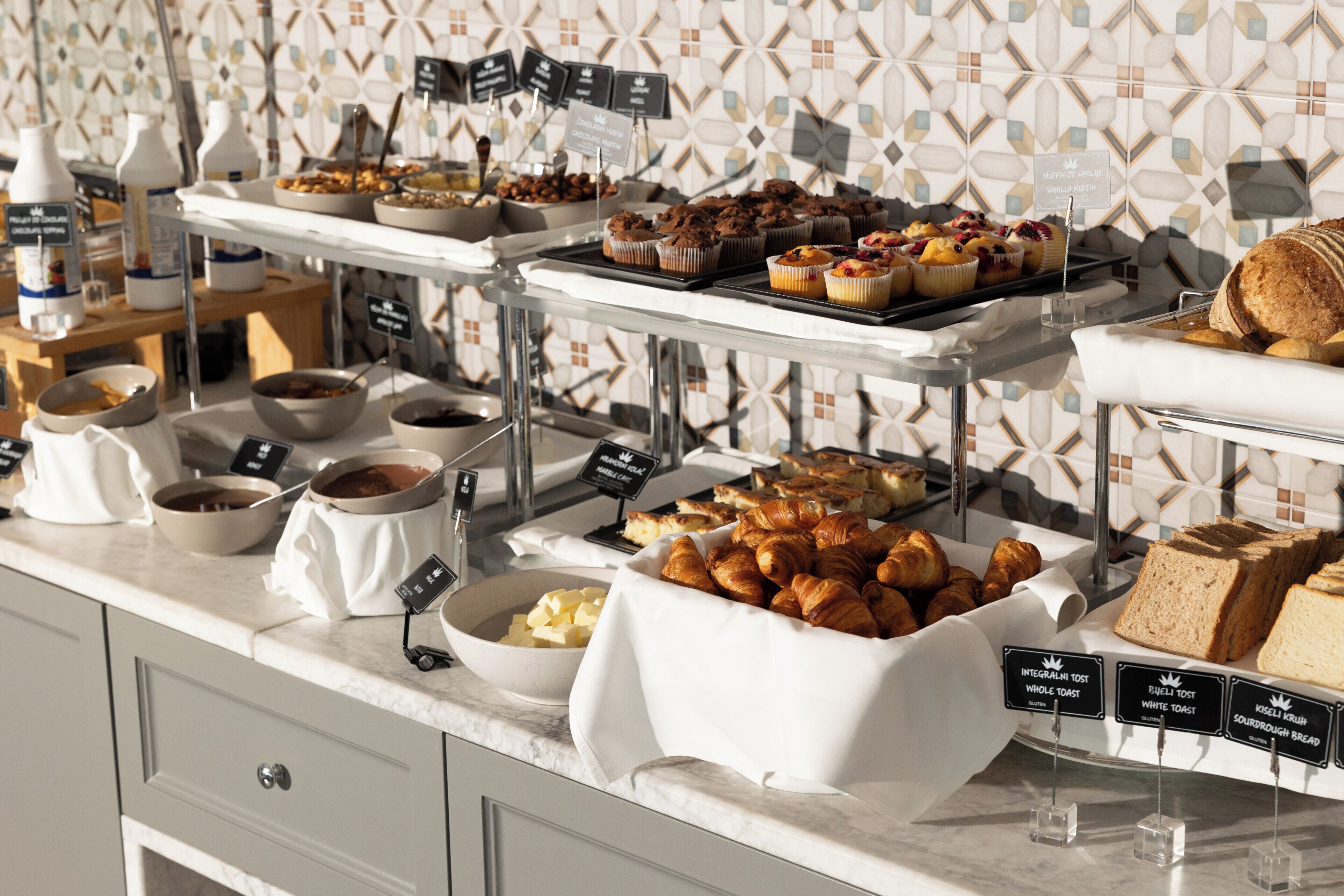 A buffet with various food items and labels.
