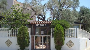 Un bâtiment avec une enseigne indiquant « RISTORO » et une entrée fermée par un portail.